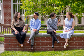 Young church leaders chatting on a wall in the Sterling Divinity Quadrangle at Yale